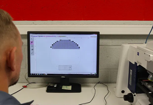 Tecnico che analizza le particelle al microscopio